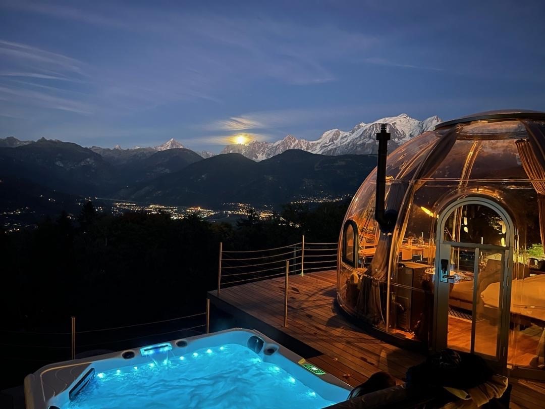 Bulle transparente pour dormir installée dans la nature sous un ciel étoilé