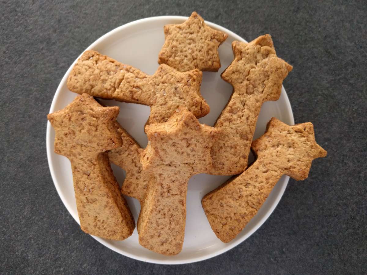 Biscuits de Noël maison décorés au sucre glace sur une plaque de cuisson