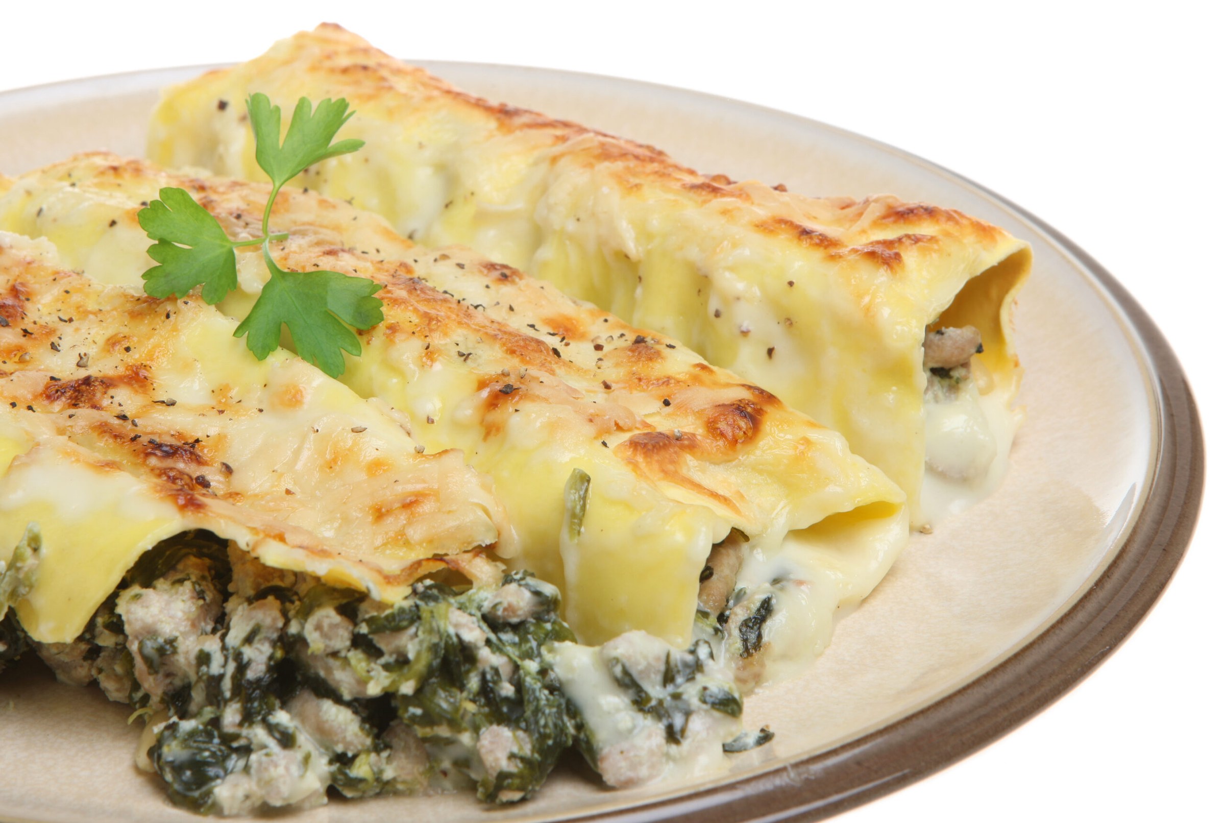 Cannelloni farcis nappés de sauce tomate et de fromage, gratinés dans un plat au four
