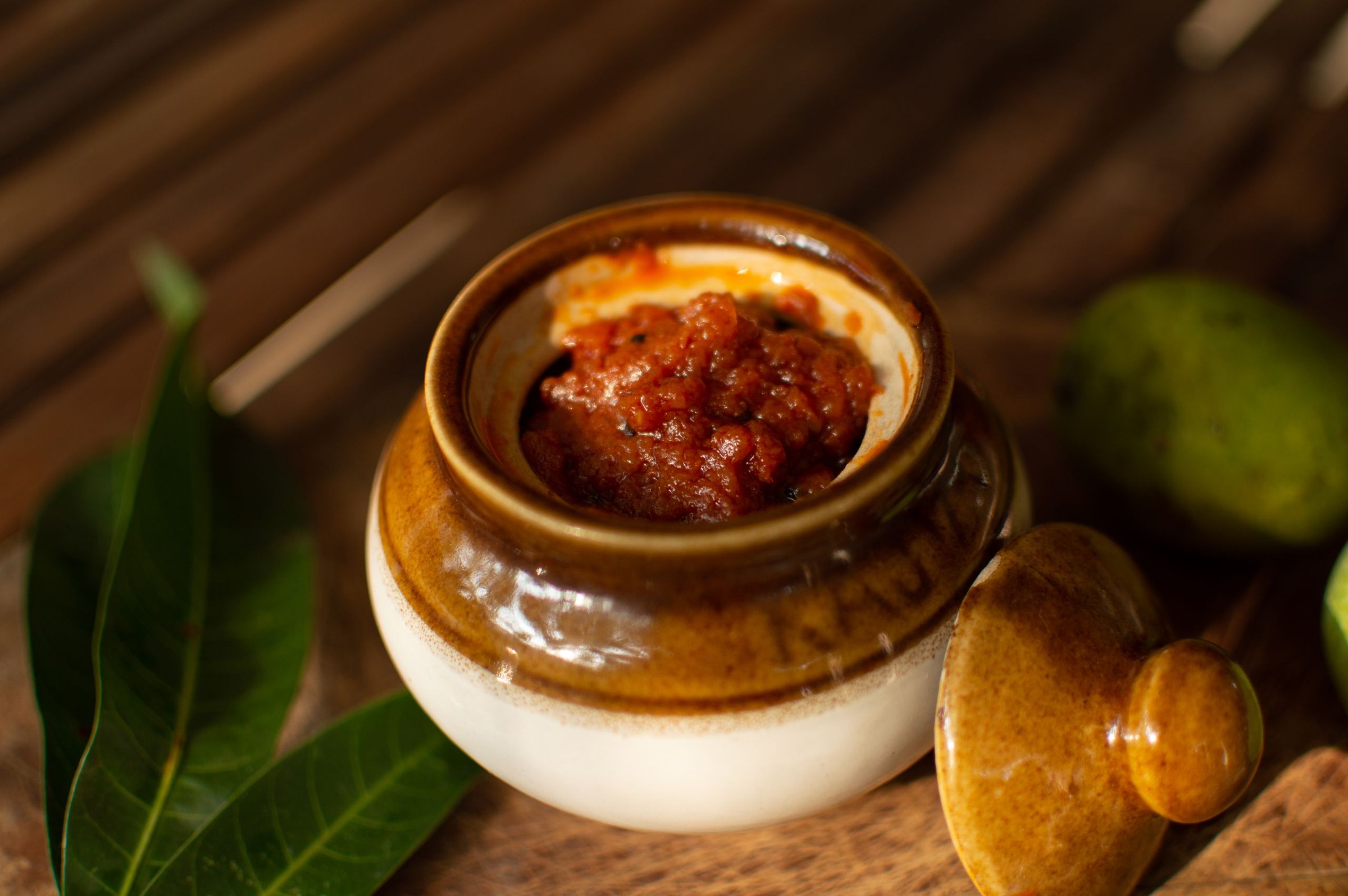 Petit pot de chutney de mangue épicé servi avec du pain et des accompagnements