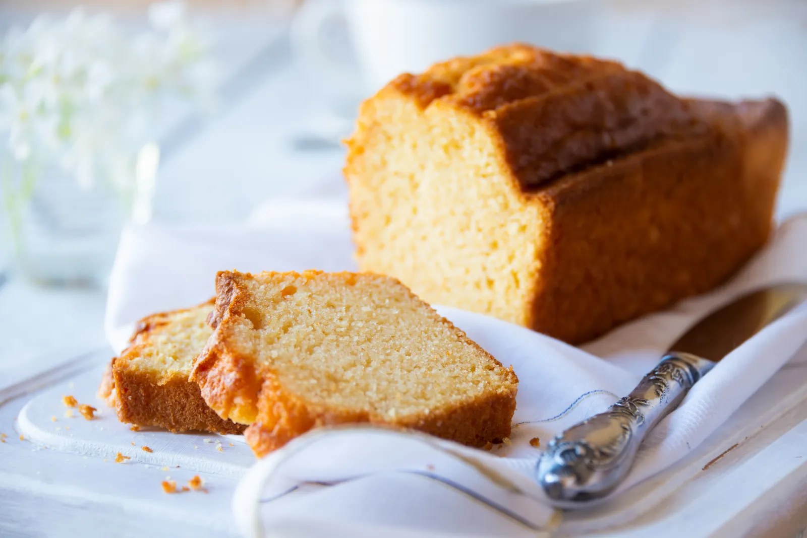 Cake banane moelleux tranché sur une planche en bois, mie dense et humide