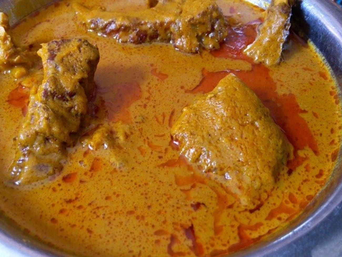 Sauce graine orangée à la noix de palme mijotée en cocotte avec poisson fumé